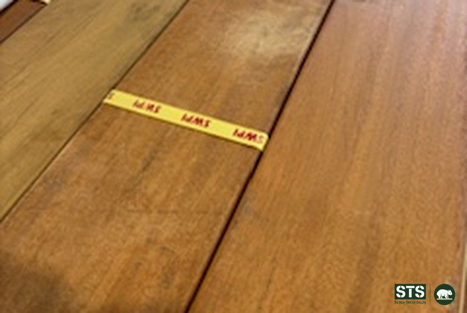 Three 140 x 19 Peninsula Blonde hardwood decking boards lying side by side with a yard tally tag, showing board to board tone difference